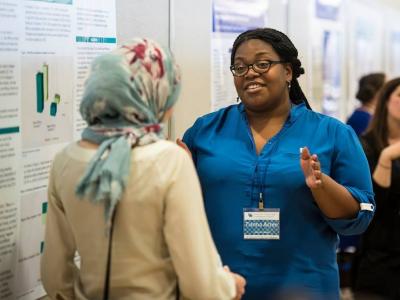 Two Participants Discussing Poster Presentations at the 2018 Spring Conference Poster Session