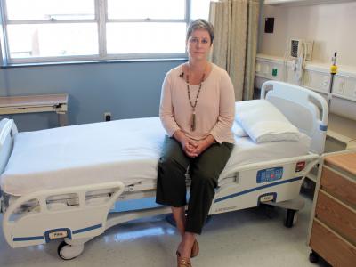 Aime Kunes sits on a hospital bed in the CCTS Inpatient Research Unit