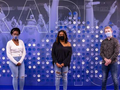 Three undergraduate students stand in front of a blue and gray wall-- the 2020 SPARK student researchers Hope Makumbi, Alexis James and Roberto Obregon Garcia. Pete Comparoni | UK Photo.
