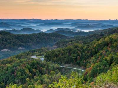 Landscape arial view of Appalachia, the forested mountains in the foreground and blue, misty mountains in the background. 