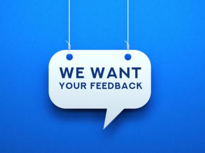 A white sign in the shape of a speech bubble says "We Want Your Feedback" in blue text. The sign hangs on white strings in front of a blue background. 