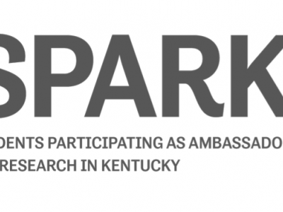Logo for the SPARK program: On the right is a stylized square star shape in green, blue, purple and yellow. To the left is the word SPARK in large, bold, capital letters, under which reads "Students Participating as Ambassadors for Research in Kentucky"