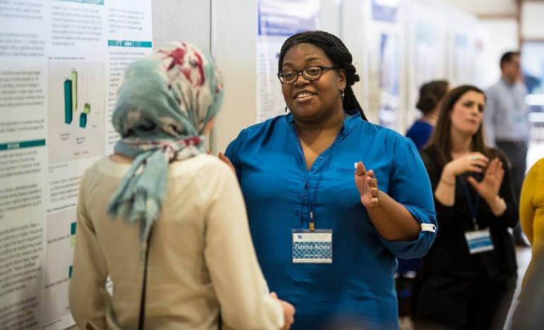 Two Participants Discussing Poster Presentations at the 2018 Spring Conference Poster Session