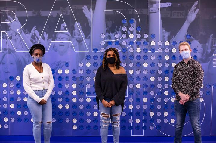 Three undergraduate students stand in front of a blue and gray wall-- the 2020 SPARK student researchers Hope Makumbi, Alexis James and Roberto Obregon Garcia. Pete Comparoni | UK Photo.