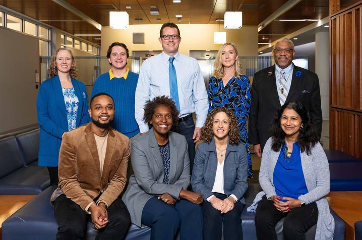 Photo shows 9 members of the UK ASCEND team, four seated and five standing behind them. Front row: Justin Moore, Lovoria Williams, Nancy Schoenberg, Shyanika Rose. Back row: Pamela Hull, Jimmy Robinson, Kevin Pearson, Hilary Surratt, Darwin Conwell. Not pictured: Carolyn Lauckner, Misti Salyers-Dunford. Jeremy Blackburn, ResComm