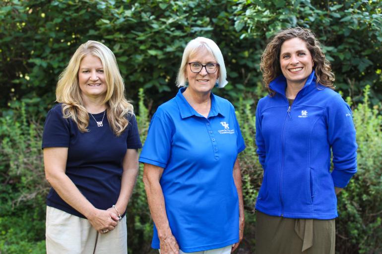 The CCTS Biobank team, which consists of three women standing side by side in front of trees. 
