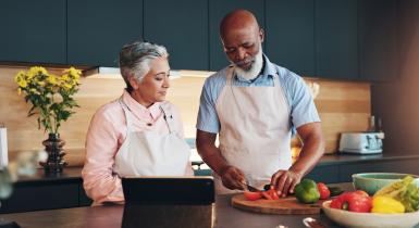 Healthy man and women cooking.