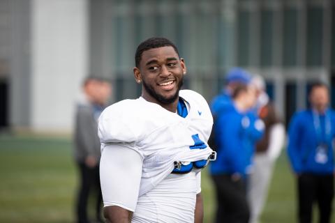 Joshua Paschal smiling on the football field. 